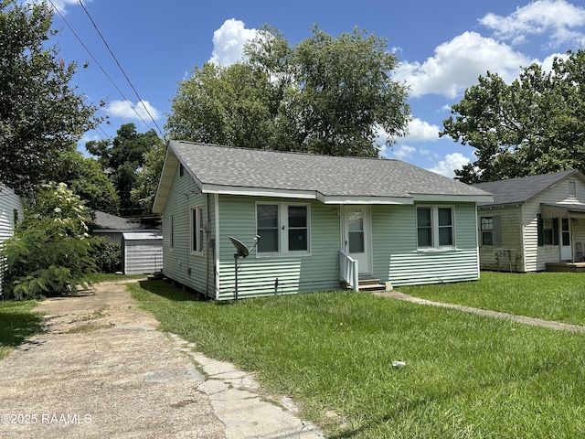 627 S Railroad Ave, Opelousas, LA 70570 - bungalow-style home with entry steps, roof with shingles, a front yard, and driveway