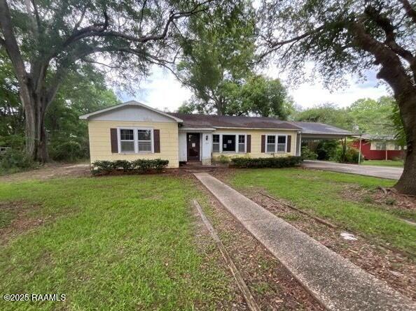 109 Pecan St, Ville Platte, LA 70586 - single story home featuring concrete driveway, a front yard, and a carport