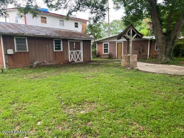 109 Pecan St, Ville Platte, LA 70586 - view of green lawn with an outbuilding