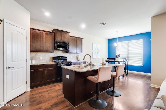 206 Agrarian Ave, Rayne, LA 70578 - kitchen with gas stove, a sink, a kitchen island with sink, a kitchen bar, and tasteful backsplash