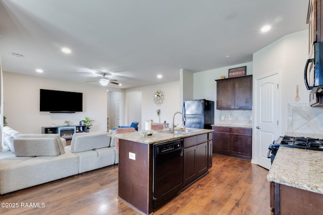 206 Agrarian Ave, Rayne, LA 70578 - kitchen with black appliances, a sink, tasteful backsplash, dark brown cabinets, and a kitchen island with sink