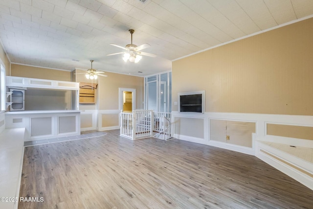 315 Tissington St, Lafayette, LA 70501 - unfurnished living room with ornamental molding, a decorative wall, a ceiling fan, wood finished floors, and a wainscoted wall