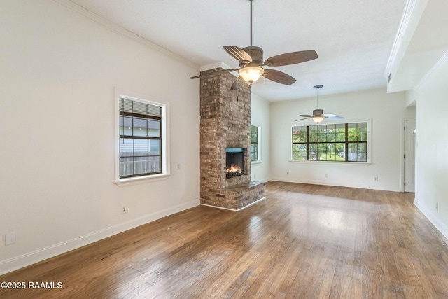 315 Tissington St, Lafayette, LA 70501 - unfurnished living room featuring ceiling fan, wood finished floors, a brick fireplace, crown molding, and baseboards