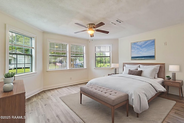 315 Tissington St, Lafayette, LA 70501 - bedroom with ornamental molding, light wood-style flooring, baseboards, a ceiling fan, and a textured ceiling