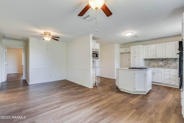 315 Tissington St, Lafayette, LA 70501 - kitchen with a ceiling fan, white cabinets, wood finished floors, ornamental molding, and stainless steel microwave
