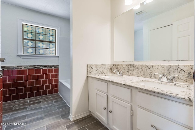 315 Tissington St, Lafayette, LA 70501 - full bath with double vanity, tile walls, wood tiled floors, and a tub to relax in