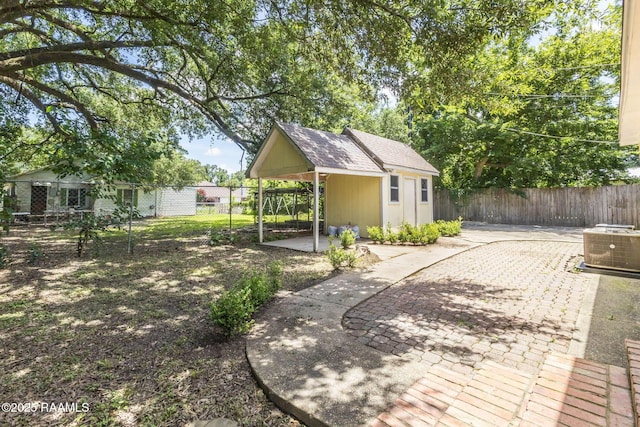 315 Tissington St, Lafayette, LA 70501 - fenced backyard with a patio, an outdoor structure, and a carport