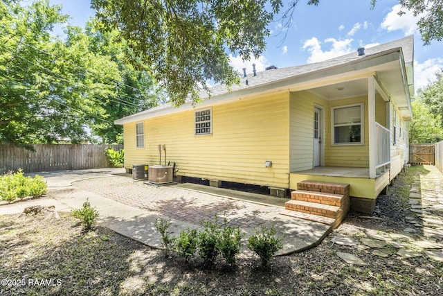 315 Tissington St, Lafayette, LA 70501 - back of house featuring a fenced backyard, a patio, roof with shingles, and central AC unit