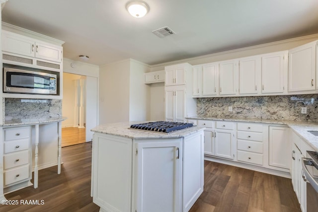 315 Tissington St, Lafayette, LA 70501 - kitchen featuring appliances with stainless steel finishes, dark wood-style flooring, white cabinetry, decorative backsplash, and ornamental molding