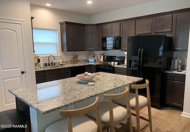 209 Crescent View Ln, Duson, LA 70529 - kitchen featuring black appliances, a sink, dark brown cabinetry, a kitchen breakfast bar, and recessed lighting