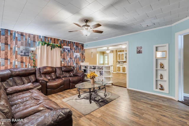1521 Saint Jude Ave, New Iberia, LA 70560 - living room featuring ceiling fan, crown molding, wood finished floors, built in shelves, and wood walls