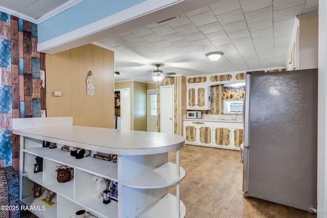 1521 Saint Jude Ave, New Iberia, LA 70560 - kitchen with freestanding refrigerator, open shelves, ornamental molding, light countertops, and light wood finished floors
