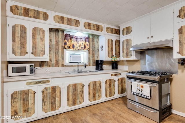 1521 Saint Jude Ave, New Iberia, LA 70560 - kitchen with white microwave, stainless steel range with gas cooktop, under cabinet range hood, and light countertops