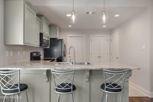 310 Harvest Ln, Abbeville, LA 70510 - kitchen featuring appliances with stainless steel finishes, a peninsula, tasteful backsplash, a kitchen breakfast bar, and recessed lighting