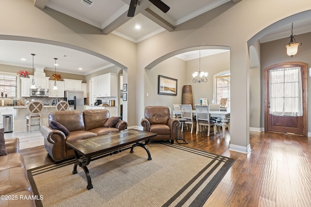 105 Cane Creek Dr, Broussard, LA 70518 - living room featuring arched walkways, ceiling fan, wood-type flooring, ornamental molding, and a chandelier