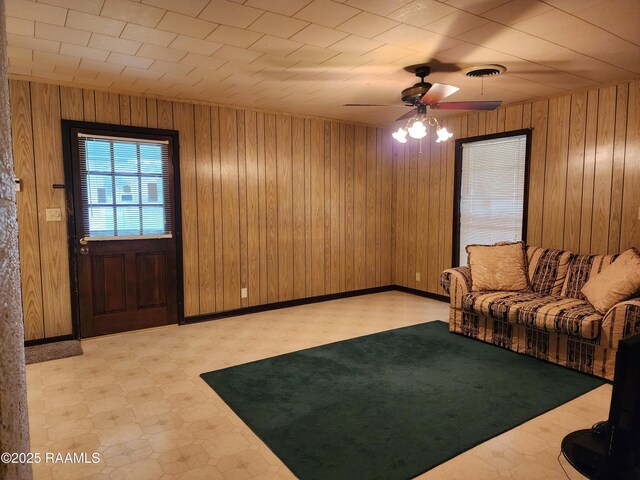 2115 Vige St, Opelousas, LA 70570 - living room featuring tile patterned floors, ceiling fan, and wooden walls