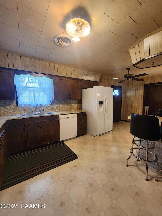2115 Vige St, Opelousas, LA 70570 - kitchen featuring white appliances, a sink, light floors, light countertops, and wood walls