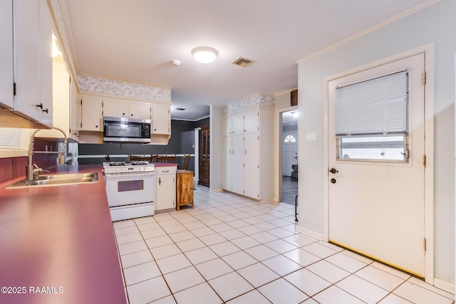 938 Marteau Rd, Broussard, LA 70518 - kitchen featuring white range with gas stovetop, stainless steel microwave, a sink, crown molding, and white cabinets