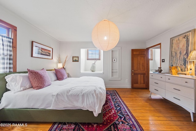 3000 E Simcoe St, Lafayette, LA 70501 - bedroom featuring light wood finished floors, multiple windows, ornamental molding, and baseboards