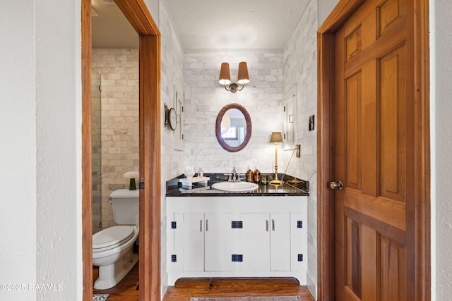 3000 E Simcoe St, Lafayette, LA 70501 - bathroom with vanity, toilet, tile walls, and a textured ceiling