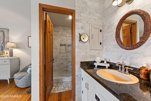 3000 E Simcoe St, Lafayette, LA 70501 - bathroom with vanity, a tile shower, and wood finished floors