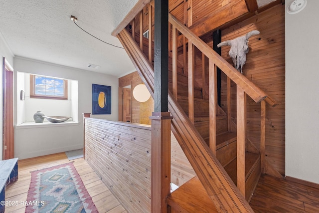 3000 E Simcoe St, Lafayette, LA 70501 - staircase featuring wood finished floors, baseboards, and a textured ceiling