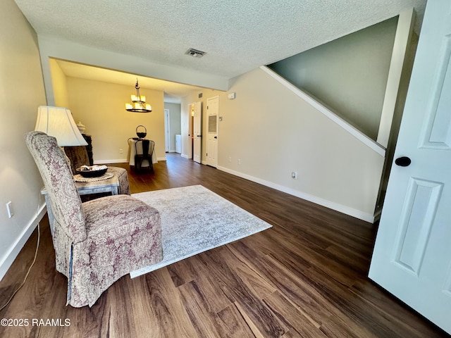 201 High Meadows Blvd Unit 205, Lafayette, LA 70507 - sitting room with dark wood finished floors, baseboards, a textured ceiling, and a chandelier