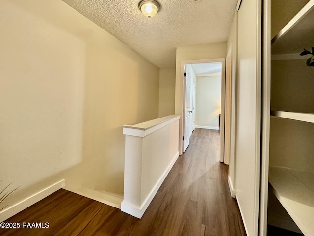 201 High Meadows Blvd Unit 205, Lafayette, LA 70507 - hall featuring dark wood-type flooring, a textured ceiling, baseboards, and an upstairs landing