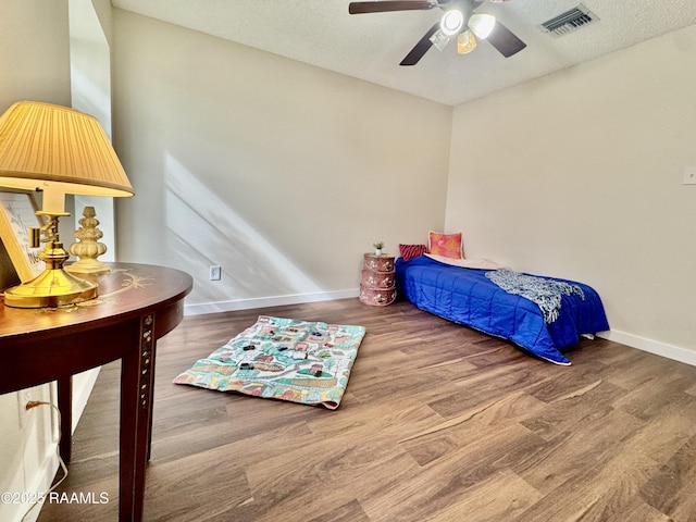 201 High Meadows Blvd Unit 205, Lafayette, LA 70507 - bedroom with wood finished floors, baseboards, a textured ceiling, and a ceiling fan