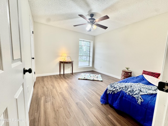 201 High Meadows Blvd Unit 205, Lafayette, LA 70507 - bedroom with wood finished floors, a textured ceiling, baseboards, and a ceiling fan