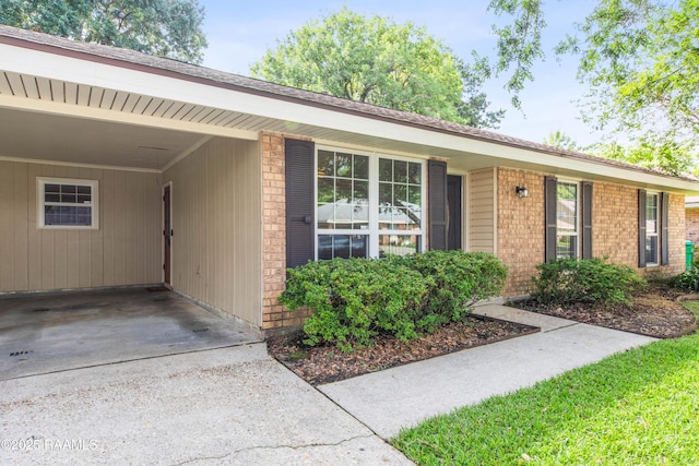 315 Orgeron Dr, Lafayette, LA 70506 - view of front facade with concrete driveway, an attached carport, and brick siding
