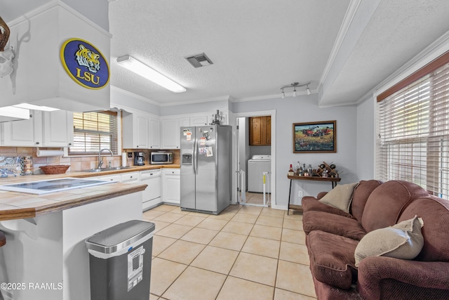 315 Orgeron Dr, Lafayette, LA 70506 - kitchen featuring appliances with stainless steel finishes, tile countertops, crown molding, light tile patterned flooring, and white cabinets