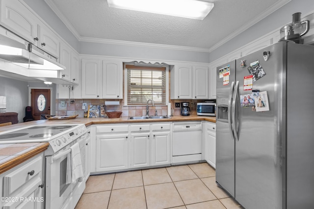 315 Orgeron Dr, Lafayette, LA 70506 - kitchen featuring appliances with stainless steel finishes, white cabinetry, crown molding, light tile patterned floors, and backsplash