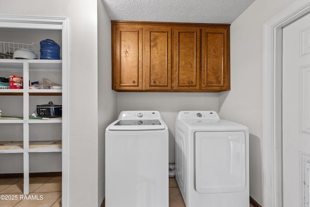 315 Orgeron Dr, Lafayette, LA 70506 - laundry room featuring separate washer and dryer, cabinet space, a textured ceiling, and tile patterned flooring