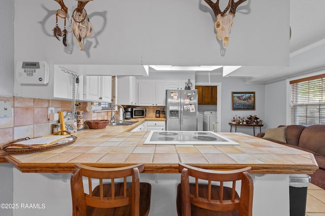 315 Orgeron Dr, Lafayette, LA 70506 - kitchen featuring stainless steel appliances, washer and clothes dryer, a kitchen breakfast bar, a peninsula, and ornamental molding