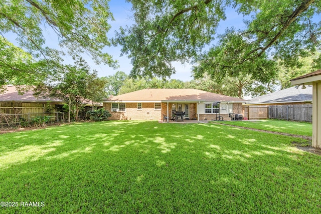 315 Orgeron Dr, Lafayette, LA 70506 - rear view of house with brick siding, a patio area, and a fenced backyard