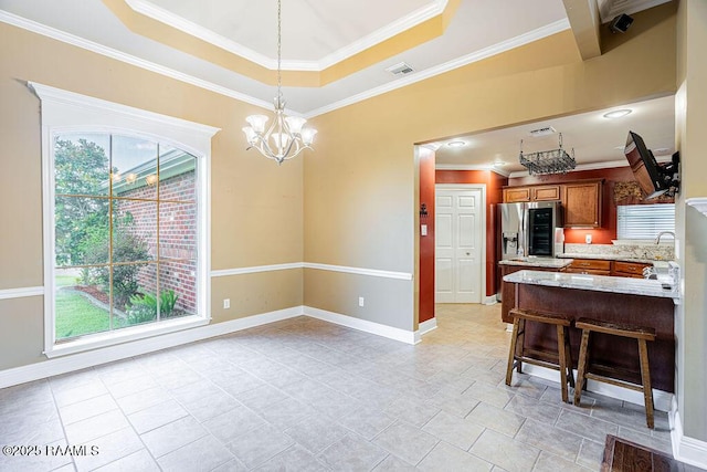 202 Doe Ln, Broussard, LA 70518 - kitchen featuring stainless steel refrigerator with ice dispenser, brown cabinets, crown molding, a chandelier, and decorative light fixtures