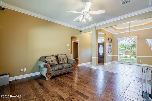 202 Doe Ln, Broussard, LA 70518 - living area featuring wood finished floors, a ceiling fan, ornamental molding, a raised ceiling, and a chandelier