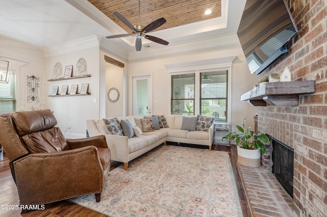 302 Easy Rock Landing Dr, Broussard, LA 70518 - living room featuring a fireplace, crown molding, a ceiling fan, wood finished floors, and a tray ceiling