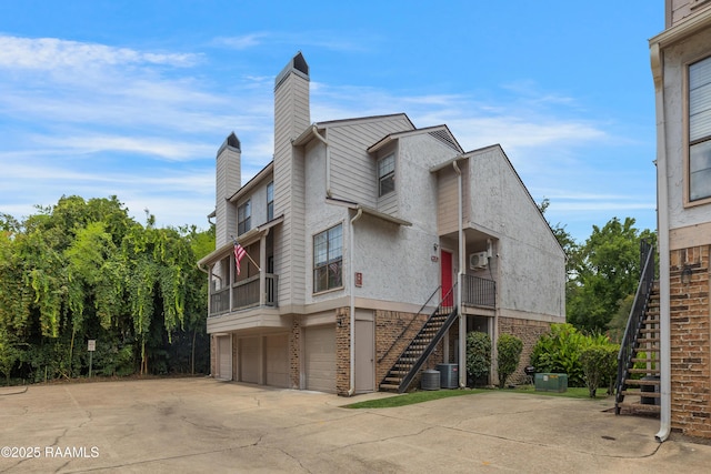 1304 E Bayou Pkwy Unit 8A, Lafayette, LA 70508 - view of home's exterior with stairway, a garage, a chimney, and driveway