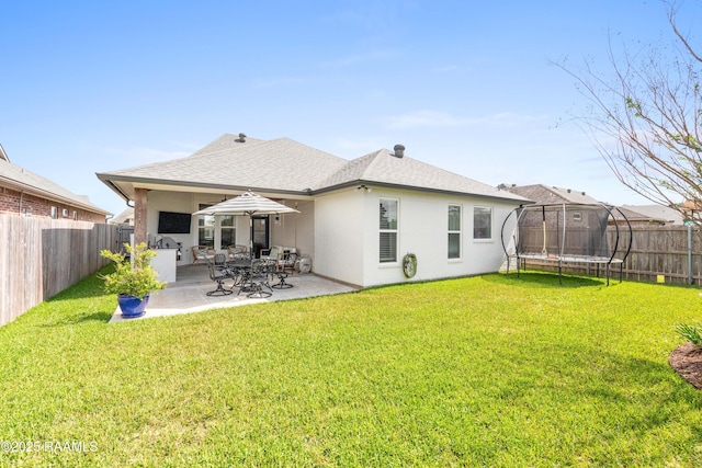 236 Whispering Meadows Rd, Broussard, LA 70518 - back of property with a trampoline, a patio, a fenced backyard, and a shingled roof