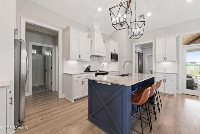 236 Whispering Meadows Rd, Broussard, LA 70518 - kitchen with appliances with stainless steel finishes, backsplash, white cabinetry, light wood-style flooring, and a kitchen bar