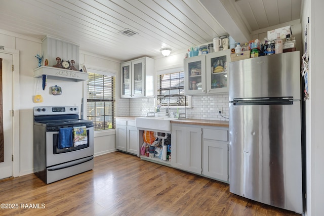 145 Celestine Ln, Sunset, LA 70584 - kitchen featuring stainless steel appliances, wooden ceiling, decorative backsplash, glass insert cabinets, and wood finished floors