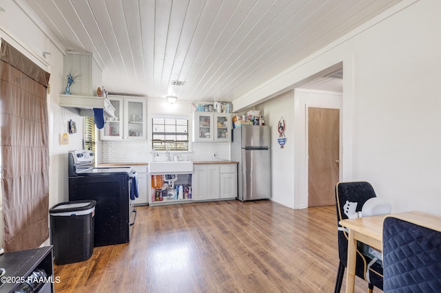 145 Celestine Ln, Sunset, LA 70584 - kitchen featuring freestanding refrigerator, electric range, light wood-style flooring, tasteful backsplash, and light countertops