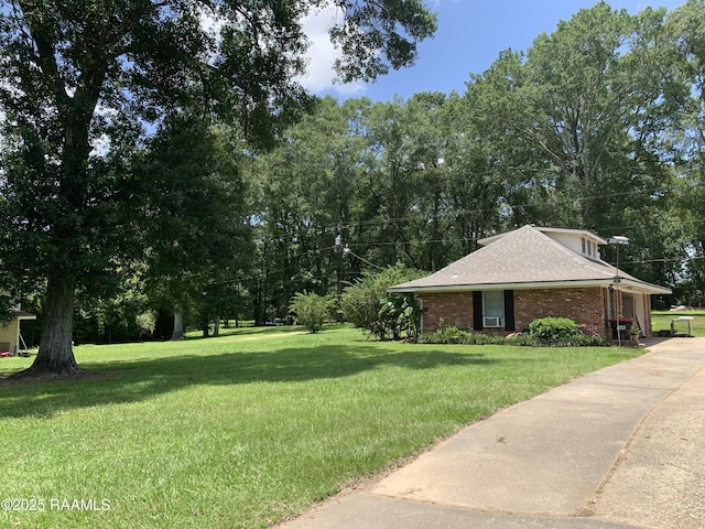 1921 E Willow St, Lafayette, LA 70501 - view of green lawn with driveway and view of wooded area