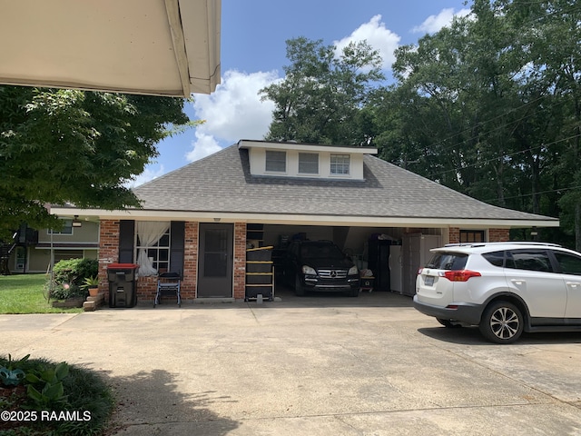 1921 E Willow St, Lafayette, LA 70501 - view of property exterior with concrete driveway, a shingled roof, a garage, and brick siding