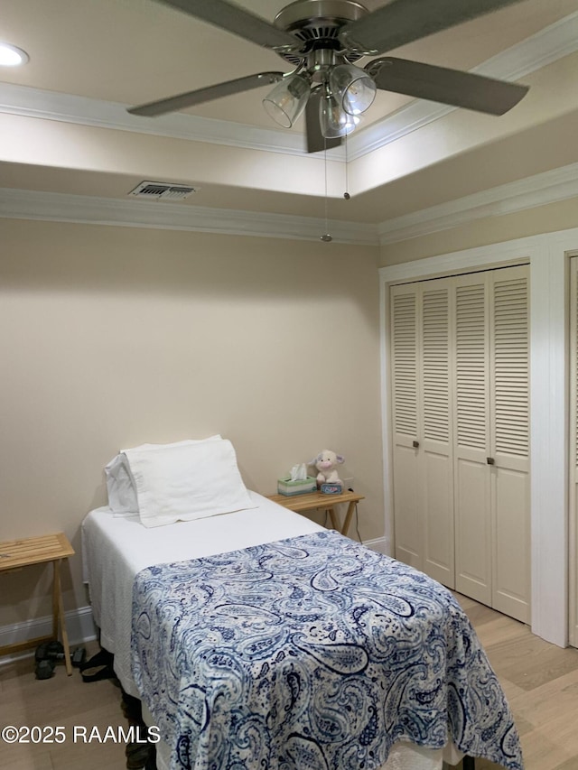 1921 E Willow St, Lafayette, LA 70501 - bedroom featuring ornamental molding, light wood-style floors, ceiling fan, and a raised ceiling