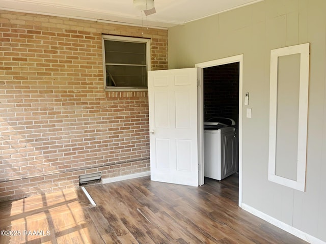 205 Joseph St, Baldwin, LA 70514 - empty room with washer / dryer, brick wall, and dark wood finished floors