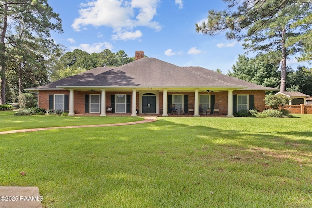 313 Darby Ln, New Iberia, LA 70560 - view of front facade with ceiling fan, a chimney, a front yard, and brick siding