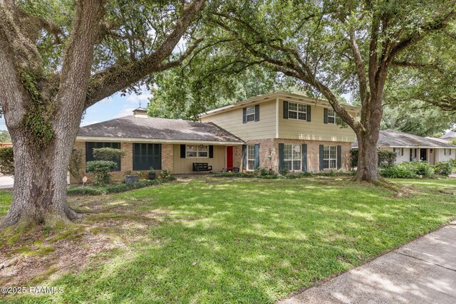 301 Broadmoor Blvd, Lafayette, LA 70503 - view of front of home with brick siding, a front yard, and a chimney
